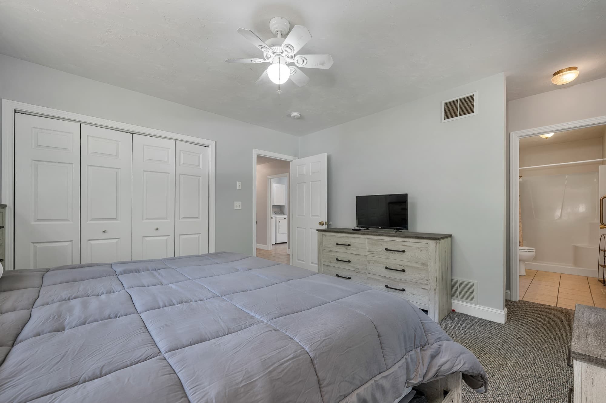 The primary bedroom's wide double closet, with the door to the private bath