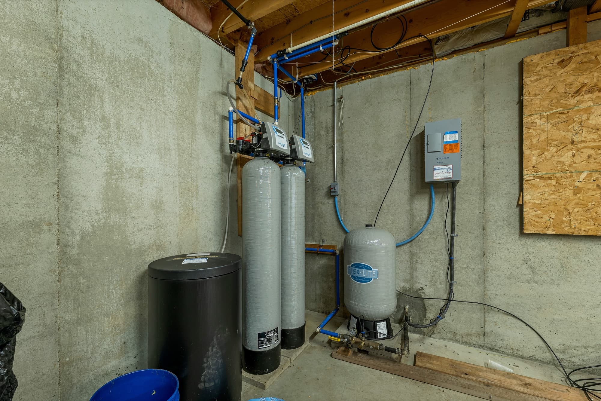 The basement water system: the pressure tank, the treatment tanks, and the panel