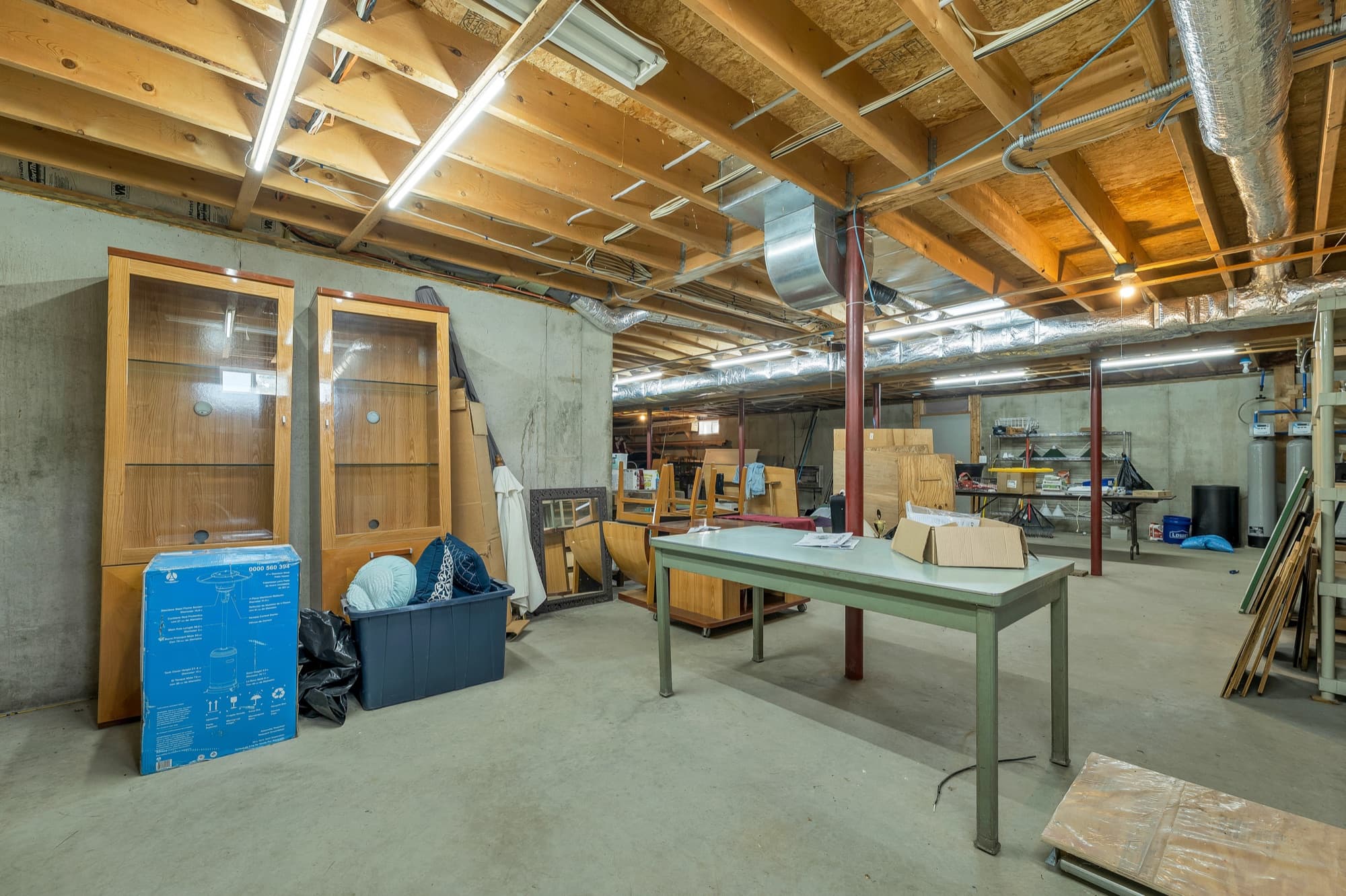 The full unfinished basement with open floor space and shelving